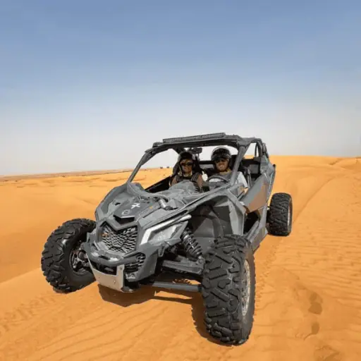 Solo driver in a 2-seater Can-Am X3 dune buggy, dust cloud trailing, Dubai desert