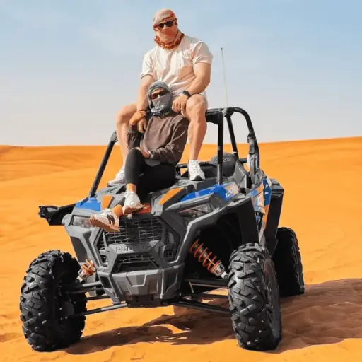 Polaris Buggy Ride for Couples – 30 Min Dune Buggy Dubai Couple driving a Polaris RZR dune buggy on Lahbab Desert Red Dunes, Dubai