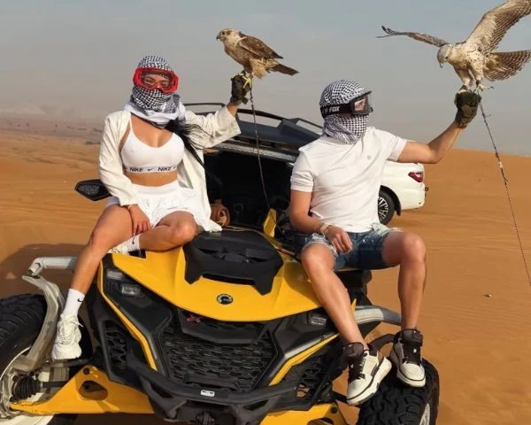 LED-lit Can-Am X3 dune buggy illuminating the night desert sand under a star-filled Dubai sky