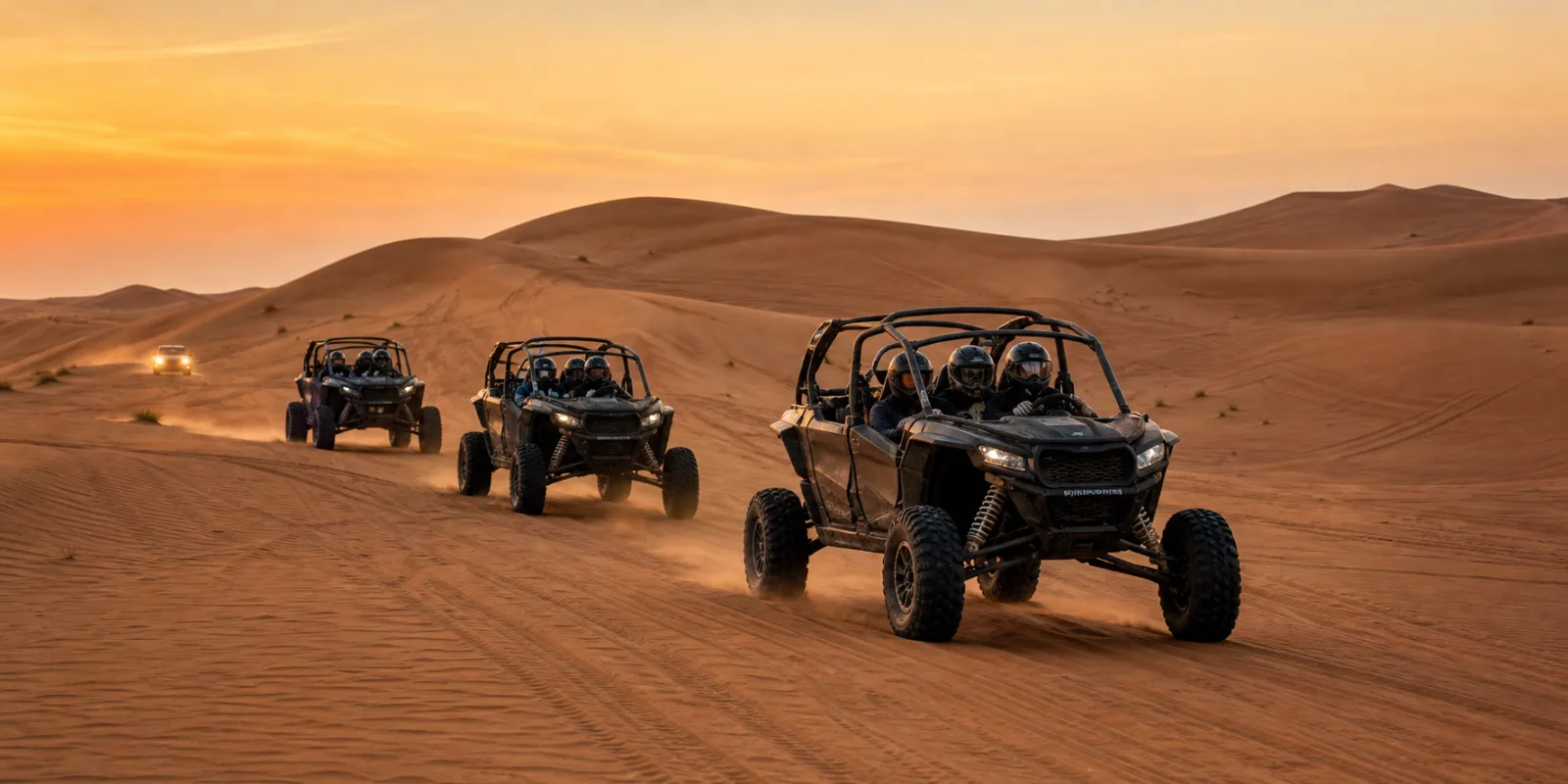 Guided dune buggy safari convoy crossing Lahbab red dunes in Dubai at golden hour