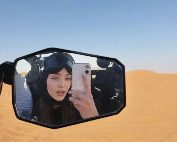 Family of four laughing inside a 4-seater Polaris dune buggy with a parent at the wheel in the Dubai desert