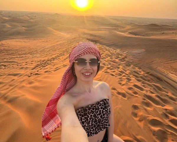 Rear tyre of a Polaris RZR throwing a wall of sand at speed through the Dubai desert dunes