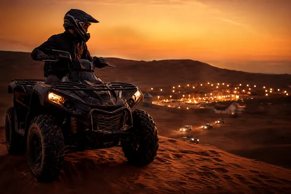 Quad bike parked on Lahbab red dunes before an evening desert safari camp