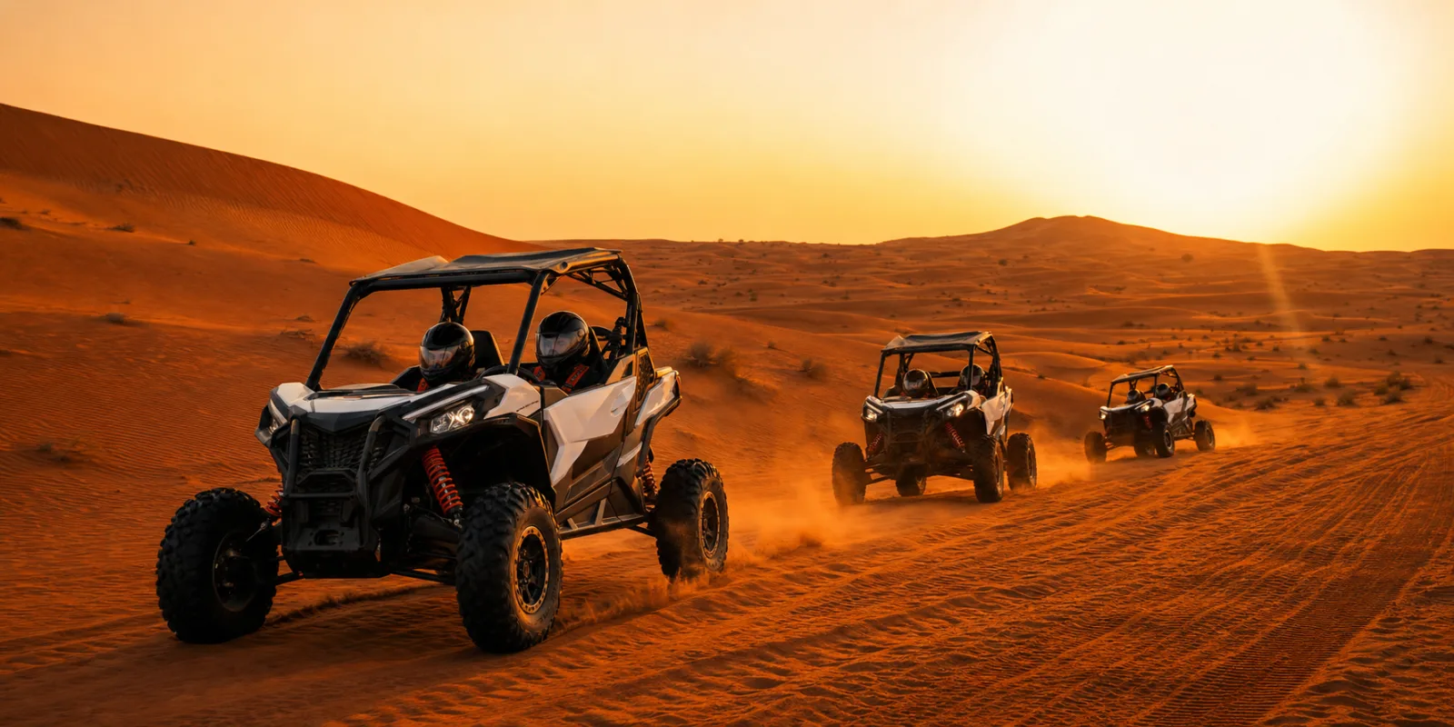 Sunset dune buggy Dubai convoy crossing Lahbab red dunes at golden hour